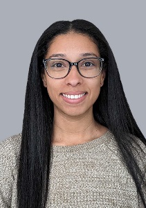 Professional headshot of female with dark hair and glasses