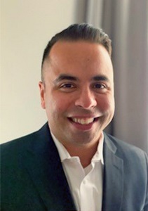 Alberto Villalobos (professional headshot of male wearing black blazer and white button up)