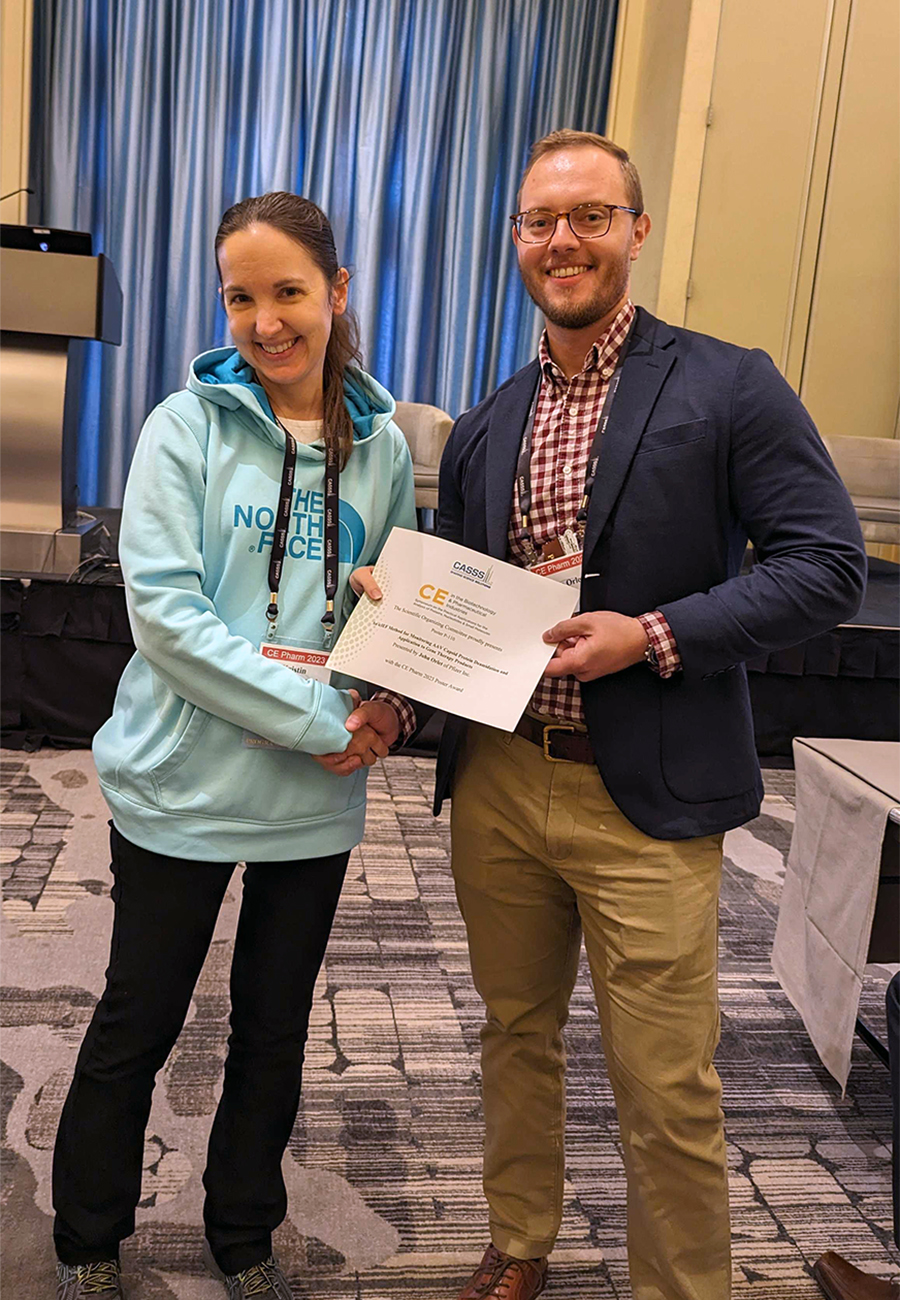 Kristin Schultz-Kuszak (female) presenting CE Pharm 2023 Poster Award to John Orlet (male) at CE Pharm Symposium 2023.