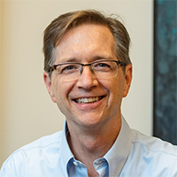 Professional headshot of male wearing glasses