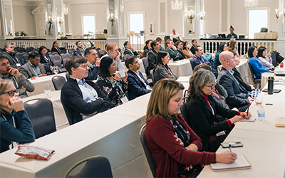 Biopharmaceutical scientists attending CASSS Symposium, listening to presentation and taking notes.